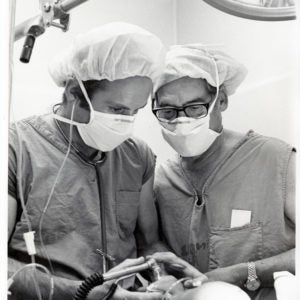 Two emergency doctors performing a procedure on baby in 1972