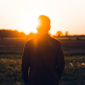 man standing with sun coming over his shoulder